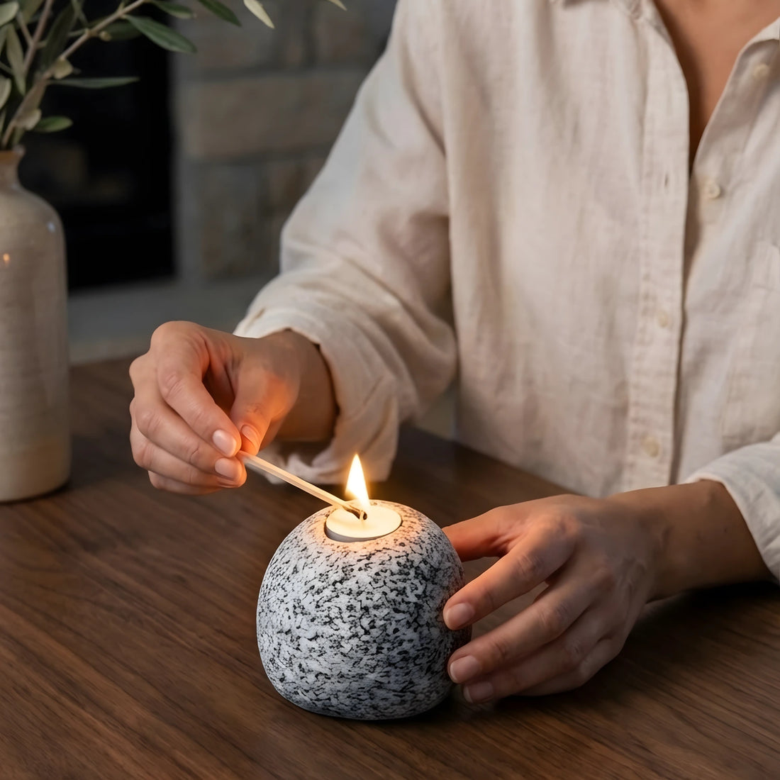 Ahşap masa üzerinde dekoratif Bergama graniti doğal taş tealight mumluk, arka planda kitap ve kupa.