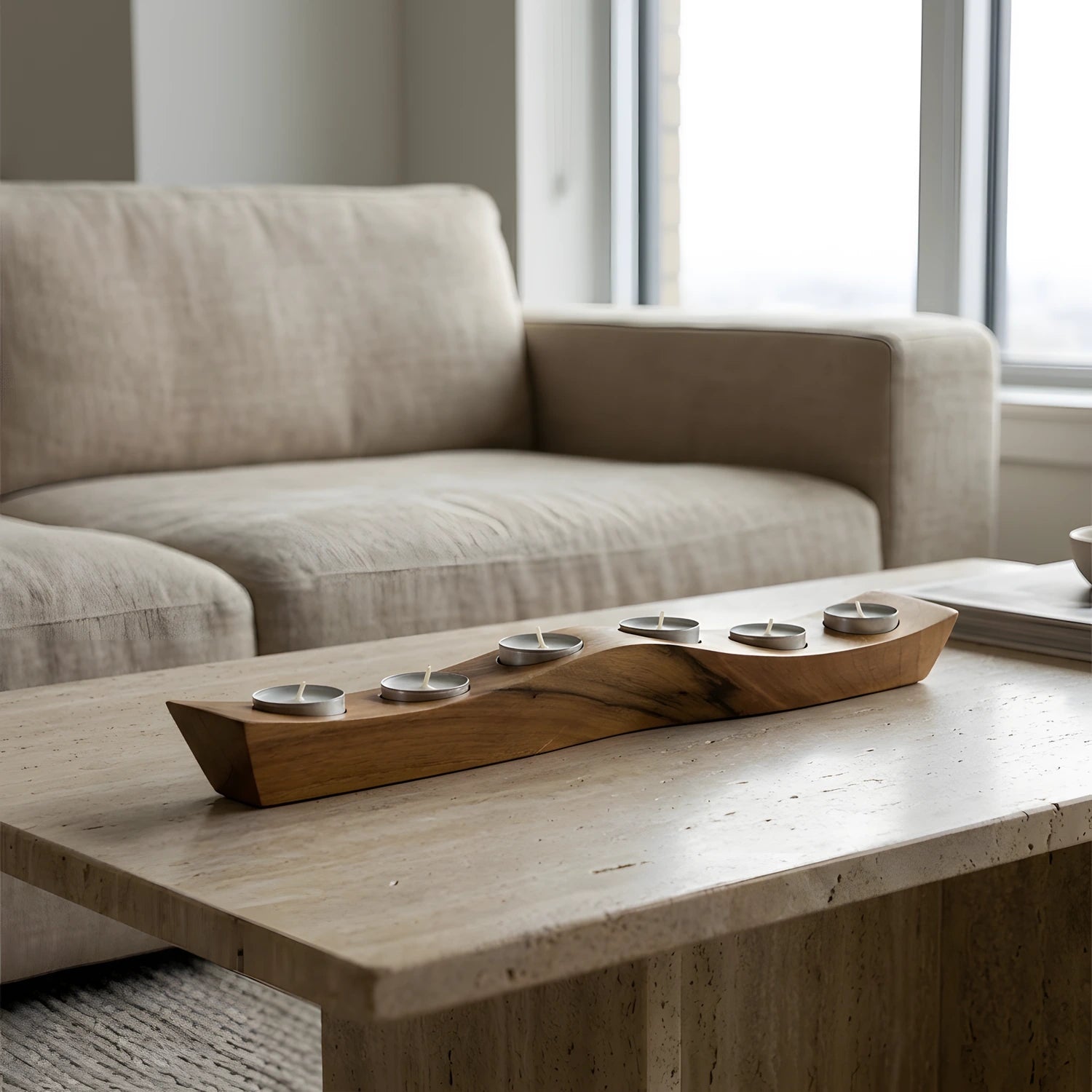 Minimalist oturma odası tasarımında orta sehpanın odak noktası olarak konumlandırılmış ceviz mumluk.